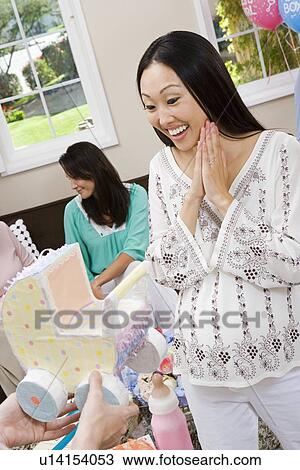 Stock Image - Pregnant Asian Woman with Friends at a Baby Shower. Fotosearch
