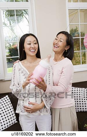 Stock Image - Pregnant Asian Woman with Mother at a Baby Shower. Fotosearch