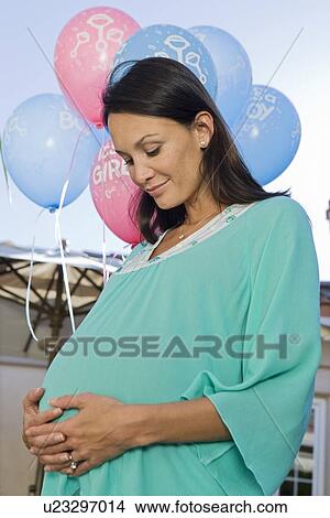 Picture - Pregnant Woman standing outside at a Baby Shower. Fotosearch