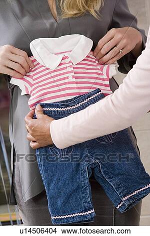 Pregnant Woman with Baby Clothes at a Baby Shower View Large Photo Image Picture - Pregnant Woman with Baby Clothes at a Baby Shower. Fotosearch