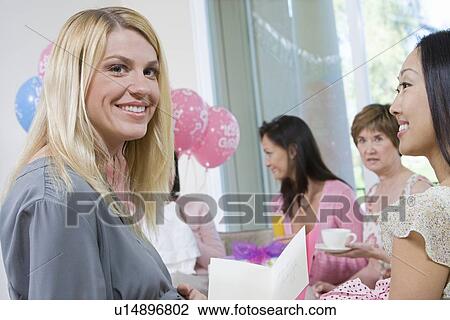 Stock Image - Pregnant Woman with friends at a Baby Shower. Fotosearch