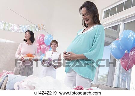 Stock Photo - Pregnant Woman with Hands on Her Stomach at baby shower. Fotosearch