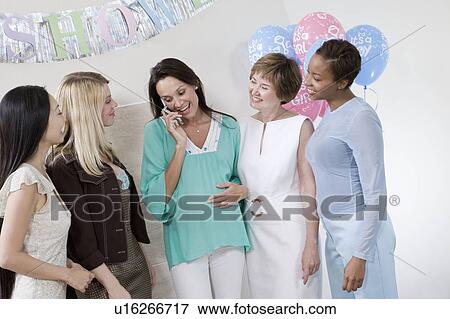 Stock Photo - Pregnant Woman with Mobile Phone at a Baby Shower. Fotosearch