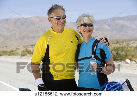 Stock Image - Senior couple in sportswear on roadside. Fotosearch