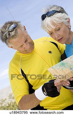 Stock Photography - Senior couple reading map. Fotosearch