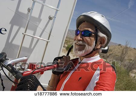 Senior man carrying bike View Large Photo Image Stock Photograph - Senior man carrying bike. Fotosearch