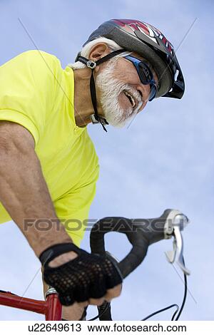Stock Image - Senior man cycling. Fotosearch
