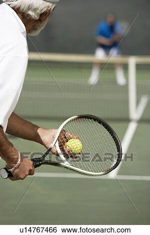 Senior Man holding racket and ball, Preparing to Serve, back view View Large Photo Image Stock Photograph - Senior Man holding racket and ball, Preparing to Serve, back view. Fotosearch