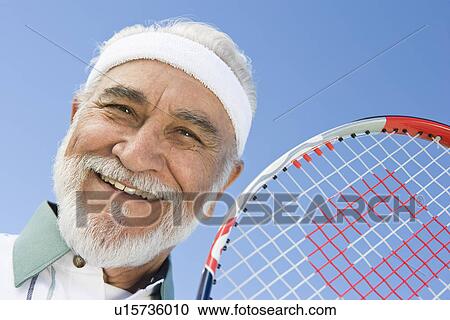 Senior man holding tennis racket, portrait View Large Photo Image Stock Image - Senior man holding tennis racket, portrait. Fotosearch