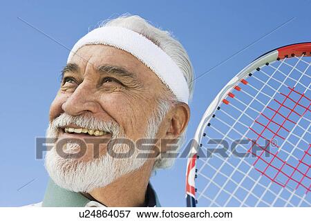 Stock Photo - Senior man holding tennis racket. Fotosearch