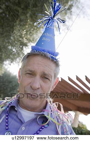 Stock Photo - Senior man in party hat. Fotosearch
