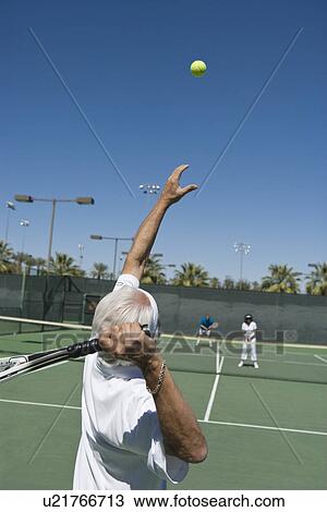 Stock Image - Senior man playing tennis. Fotosearch