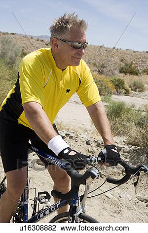 Stock Image - Senior man riding bike. Fotosearch