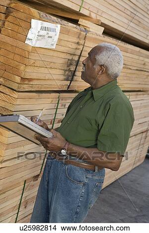 Picture - Senior man stock-taking in warehouse. Fotosearch