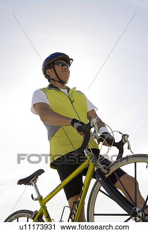 Senior man with bike, low angle view View Large Photo Image Stock Image - Senior man with bike, low angle view. Fotosearch