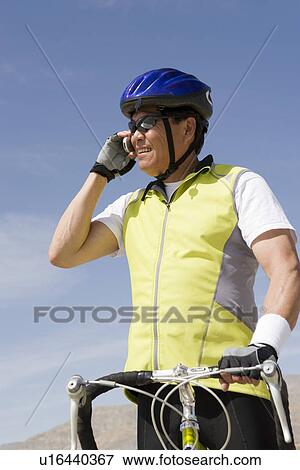 Senior man with bike talking on cell phone View Large Photo Image Stock Photo - Senior man with bike talking on cell phone. Fotosearch