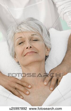 Stock Image - Senior woman having massage. Fotosearch