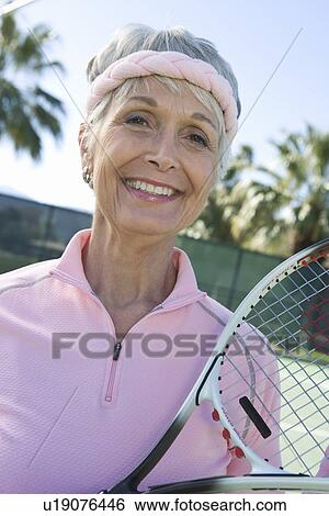Senior woman holding tennis racket, portrait View Large Photo Image Stock Photograph - Senior woman holding tennis racket, portrait. Fotosearch
