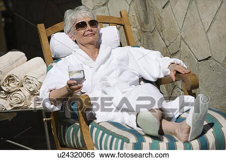 Senior woman wearing bathrobe, relaxing outdoors View Large Photo Image Stock Photography - Senior woman wearing bathrobe, relaxing outdoors. Fotosearch