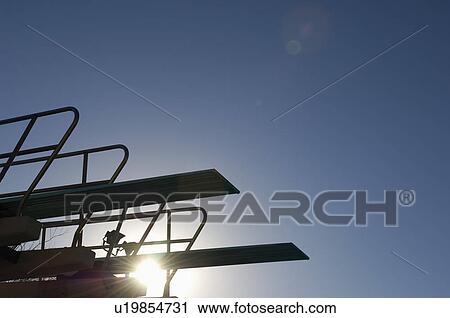 Stock Image - Silhouette of diving board at sunset. Fotosearch