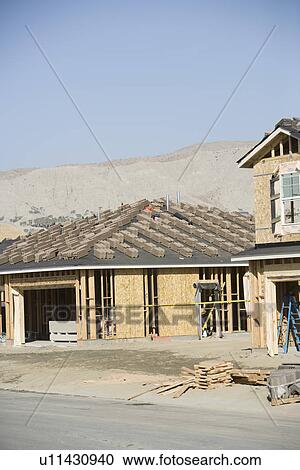 Stock Image - Stacks of tiles on house roof. Fotosearch