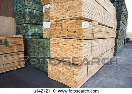 Stock Image - Stacks of wood outside warehouse. Fotosearch