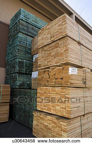 Stock Photo - Stacks of wood outside warehouse. Fotosearch