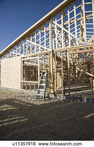 Stock Photo - Step ladder against wooden house construction. Fotosearch