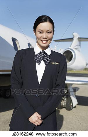 Stewardess in uniform, standing Beside a private jet View Large Photo Image Stock Photo - Stewardess in uniform, standing Beside a private jet. Fotosearch