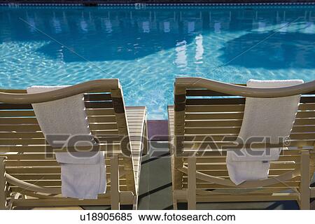 Stock Photography - Sunloungers by swimming pool. Fotosearch