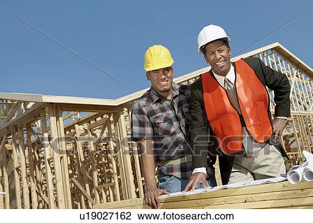Surveyor and Construction Worker looking at building plan on construction Site View Large Photo Image Stock Image - Surveyor and Construction Worker looking at building plan on construction Site. Fotosearch