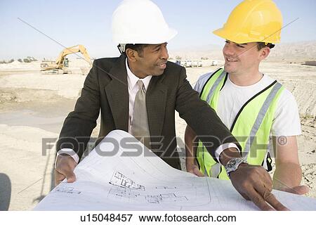 Surveyor and construction worker studying blueprint View Large Photo Image Stock Photo - Surveyor and construction worker studying blueprint. Fotosearch
