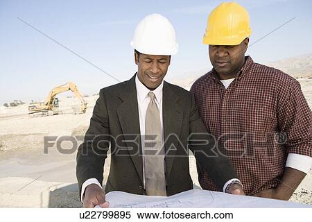 Surveyor and construction worker studying blueprint View Large Photo Image Stock Photography - Surveyor and construction worker studying blueprint. Fotosearch