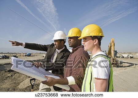 Stock Photo - Surveyor and construction workers on site. Fotosearch