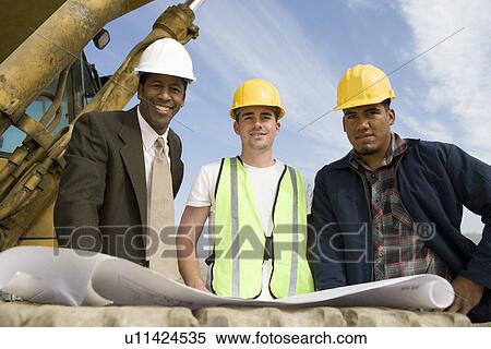 Stock Photography - Surveyor and construction workers on site, portrait. Fotosearch