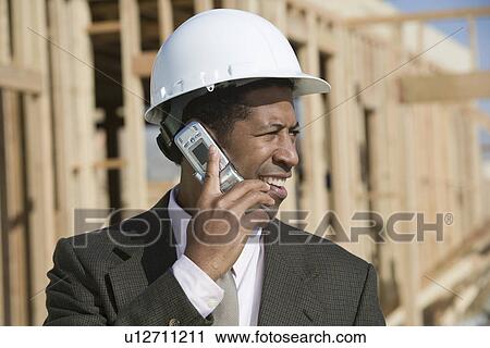 Surveyor using mobile phone on construction site View Large Photo Image Stock Image - Surveyor using mobile phone on construction site. Fotosearch