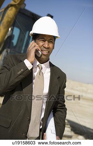 Surveyor using mobile phone on construction site View Large Photo Image Stock Image - Surveyor using mobile phone on construction site. Fotosearch