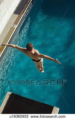 Stock Image - Swimmer jumping into swimming pool. Fotosearch