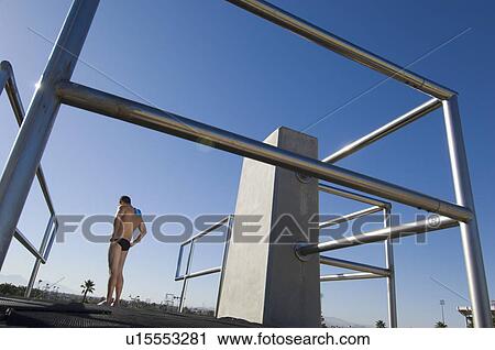 Swimmer standing on diving board View Large Photo Image Stock Image - Swimmer standing on diving board. Fotosearch