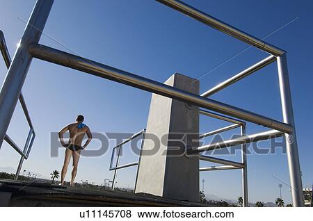 Stock Photo - Swimmer standing on diving board. Fotosearch