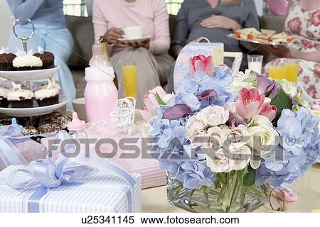 Stock Photography - Table of gifts, flowers and cakes at baby shower. Fotosearch