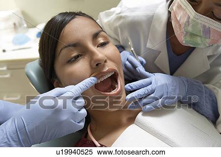 Teenage girl (13-16) at dentists, (close-up) View Large Photo Image Stock Photography - Teenage girl (13-16) at dentists, (close-up). Fotosearch