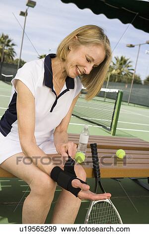 Tennis player putting on wristband View Large Photo Image Stock Photo - Tennis player putting on wristband. Fotosearch