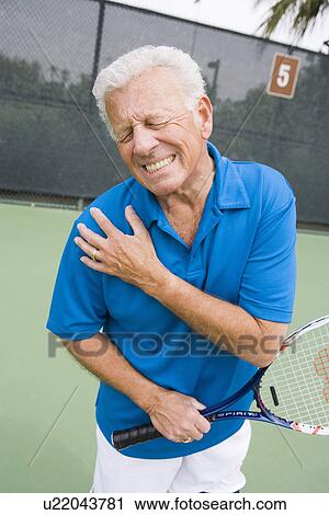 Stock Image - Tennis player suffering from shoulder injury. Fotosearch