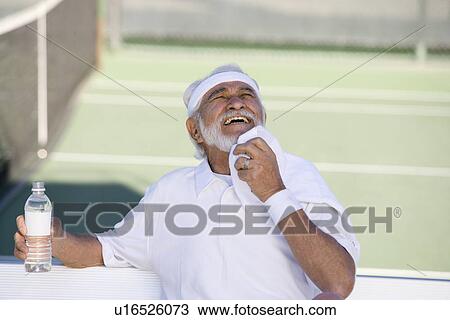 Stock Image - Tennis player toweling face. Fotosearch