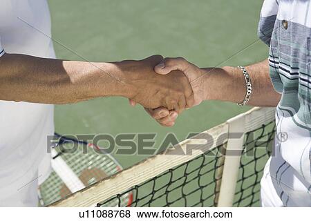 Tennis players shaking hands over net View Large Photo Image Stock Photo - Tennis players shaking hands over net. Fotosearch