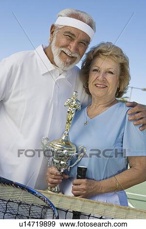 Stock Photo - Tennis players with award cup. Fotosearch