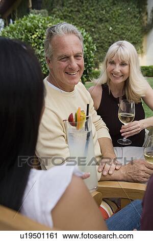 Three friends drinking wine in garden View Large Photo Image Stock Image - Three friends drinking wine in garden. Fotosearch