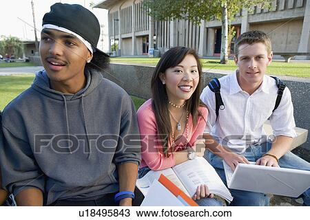 Stock Image - Three friends outside school. Fotosearch
