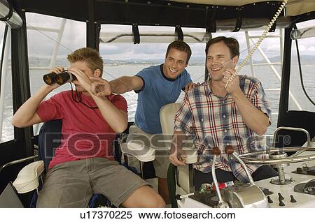 Stock Photography - Three men in boat cabin. Fotosearch